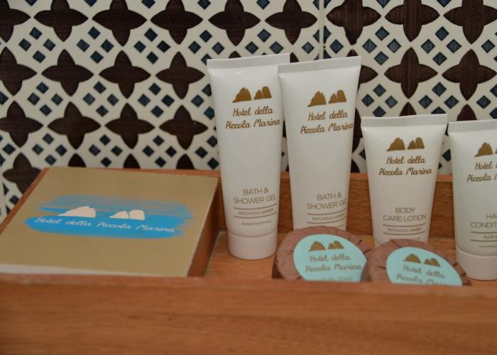 Set di cortesia elegante con profumi esotici, su sfondo piastrellato raffinato.