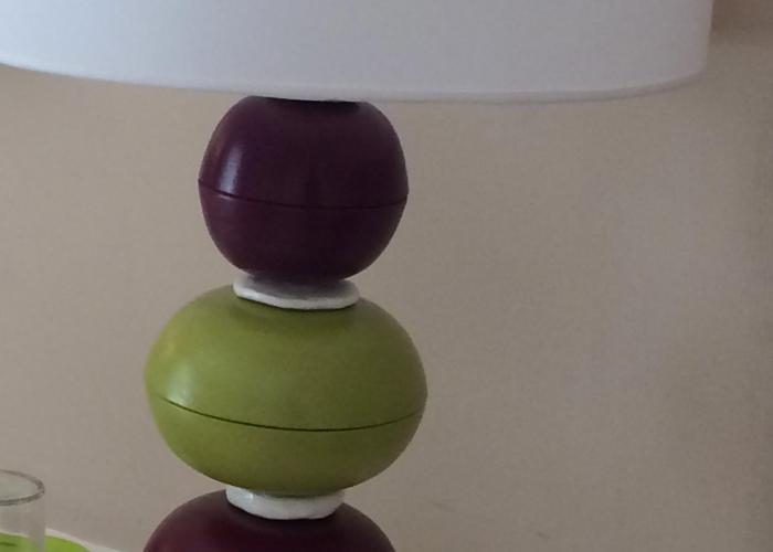 Lampada colorata con sfere verdi e viola, crea un'atmosfera moderna e vivace.